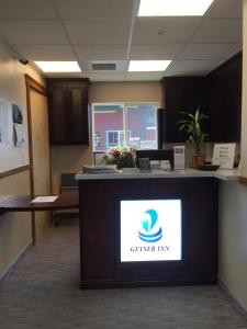 an office lobby with a reception counter with a centermark on it at Geyser Inn in West Yellowstone