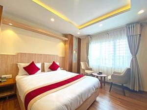 Hotel Nilakantha Pvt. Ltd في كاتماندو: غرفة فندق بسرير كبير ومخدات حمراء