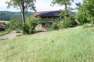 ein Haus an der Seite eines grasbewachsenen Hügels in der Unterkunft Dom noclegowy „POD MNICHEM” in Wambierzyce