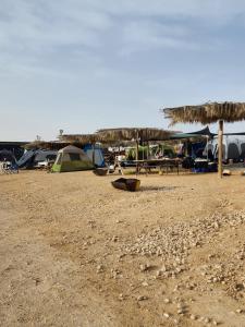 a beach with a group of tents and a campsite at חוות נועם במדבר - noam farm in Mitzpe Ramon
