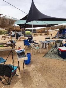 a group of tables and chairs under a tent at חוות נועם במדבר - noam farm in Mitzpe Ramon