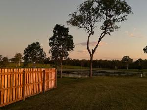 una valla de madera en un campo con un árbol en Freyjas Guest Suite en Curra