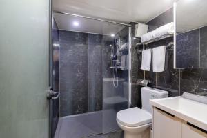 uma casa de banho com um chuveiro, um WC e um lavatório. em Xinghe Times Apartment - Shenzhen North Railway Station em Shenzhen