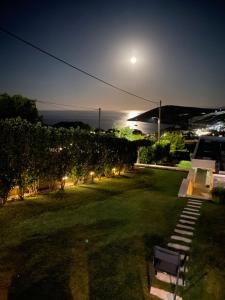 un parque con un banco en el césped por la noche en Greek Sea Villas Kaki Thalassa 400 meters to the beach en Keratea