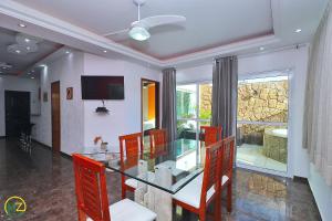 a dining room with a glass table and chairs at Linda cobertura com jaccuzzi e terraço in Rio de Janeiro