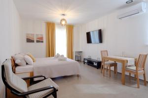 - une chambre avec un lit, une table et un bureau dans l'établissement Apartments Grape, à Pirovac