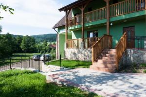 ein grünes Haus mit einer Treppe und einer Veranda in der Unterkunft Dom noclegowy „POD MNICHEM” in Wambierzyce