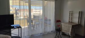 Zimmer mit einem großen Fenster mit einem Tisch und Stühlen in der Unterkunft Appartement terrasse avec vue in Valence