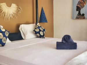 Una cama con toallas azules encima. en Promised Land Lodge, en Kizimkazi