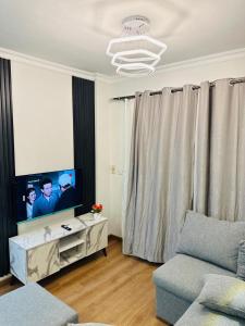 un soggiorno con divano e TV a schermo piatto di شقه مفروش الترا سوبر لوكس مدينتى a Madinaty