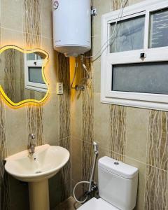 a bathroom with a sink and a toilet and a window at شقه مفروش الترا سوبر لوكس مدينتى in Madinaty