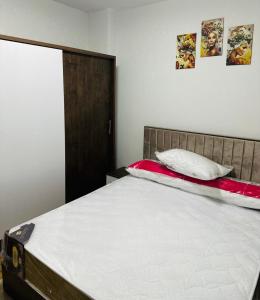 Schlafzimmer mit einem Bett mit einem roten und weißen Kissen in der Unterkunft شقه مفروش الترا سوبر لوكس مدينتى in Madinaty