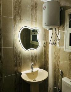 baño con lavabo y espejo en la pared en شقه مفروش الترا سوبر لوكس مدينتى, en Madinaty
