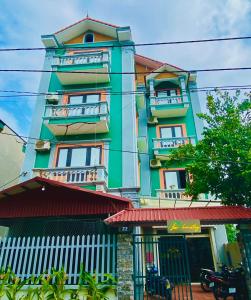 a green building with balconies on the side of it at Lion Homestay in Ninh Binh