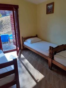 a bedroom with two beds and a sliding glass door at Apartmani Miholjska prevlaka in Tivat