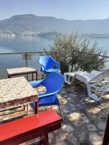 a group of chairs and tables on a patio with the water at Apartmani Miholjska prevlaka in Tivat
