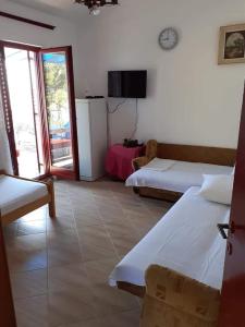 um quarto de hotel com duas camas e uma televisão em Apartmani Miholjska prevlaka em Tivat