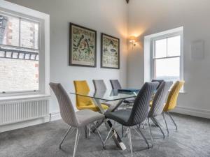 a dining room with a glass table and chairs at Pass the Keys Yew Tree Stunning Apartment with Sea View in Grange Over Sands