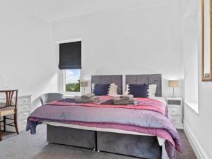 a bedroom with a large bed with a purple blanket at Pass the Keys Yew Tree Stunning Apartment with Sea View in Grange Over Sands