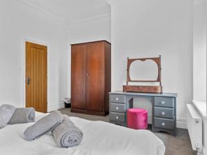 a bedroom with a bed and a dresser and a mirror at Pass the Keys Yew Tree Stunning Apartment with Sea View in Grange Over Sands