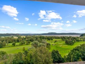 an aerial view of a golf course with trees and a lake at Pass the Keys Yew Tree Stunning Apartment with Sea View in Grange Over Sands