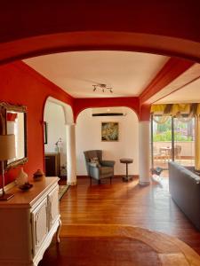 Central Exclusive Apartment/Penthouse في بيتولا: غرفة معيشة بجدران حمراء وأريكة