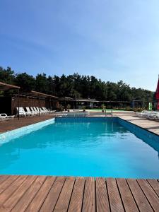 a large blue swimming pool with a wooden deck at Хижа Тополица -The beautiful view in Aytos