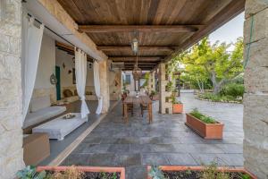 een patio met een houten plafond en een tafel bij Sunshine House - Ostuni BB di Antonella in Ceglie Messapica