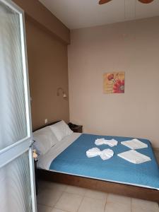 a bedroom with a bed with towels on it at GIOTAS APARTMENTS - STUDIOS in Argalasti