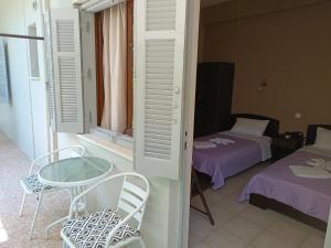 a room with a table and chairs and a bed at GIOTAS APARTMENTS - STUDIOS in Argalasti +63 photos