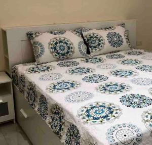 łóżko z niebiesko-białymi poduszkami w obiekcie Farmhouse with Pool and Breathtaking Views w mieście Amman