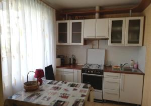 a kitchen with white cabinets and a stove and a table at 15 minutes from the Beach and city Center 7 minutes from the airport in Rīga