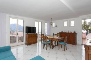 - un salon avec une table, des chaises et une télévision dans l'établissement Villa Lelle Amalfi, à Amalfi
