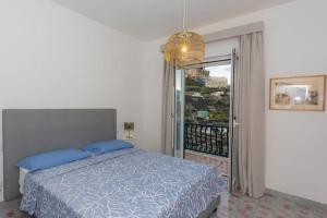 - une chambre avec un lit doté d'oreillers bleus et un balcon dans l'établissement Villa Lelle Amalfi, à Amalfi
