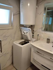 La salle de bains blanche est pourvue d'un lave-linge et d'un lavabo. dans l'établissement Apartment Valentino, à Vabriga