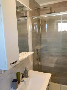 a bathroom with a white sink and a shower at Apartment Valentino in Vabriga