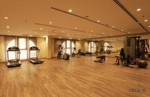 - une salle de sport avec des appareils d'exercice dans une grande pièce dans l'établissement Elegant Studio at DAMAC Lincoln Park A Arjan-Dubailand by Deluxe Holiday Homes, à Dubaï