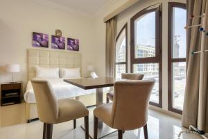 - une chambre avec un lit, une table et des chaises dans l'établissement Elegant Studio at DAMAC Lincoln Park A Arjan-Dubailand by Deluxe Holiday Homes, à Dubaï