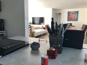 a living room with a table with a laptop and utensils at Belle Villa Baraka centre-ville in Salon-de-Provence