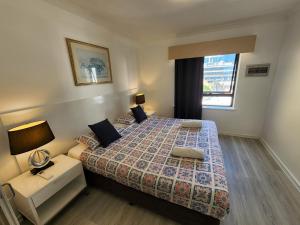 sypialnia z dużym łóżkiem i oknem w obiekcie PERTH CBD APARTMENTS w mieście Perth