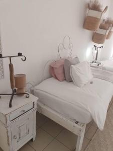 ein Schlafzimmer mit einem Bett und einem Nachttisch mit einer Lampe in der Unterkunft Whimsical in Groutfontein
