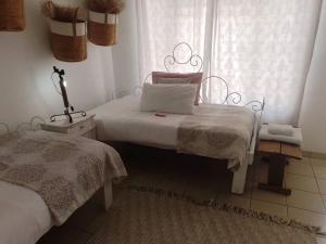 1 Schlafzimmer mit 2 Betten und einem Fenster in der Unterkunft Whimsical in Groutfontein