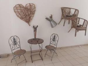einen Tisch und Stühle mit einem Herz an der Wand in der Unterkunft Whimsical in Groutfontein