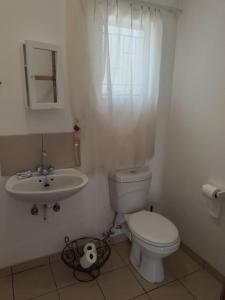 a bathroom with a toilet and a sink at Whimsical in Groutfontein