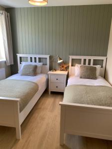 two beds sitting next to each other in a bedroom at NEW pet friendly holiday home, sleeps 6, Stromness in Stromness