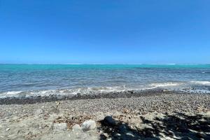 una playa con rocas y el océano en un día soleado en Blackstone Paea Premium beachfront bungalow private access wifi - 3 pers en Paea