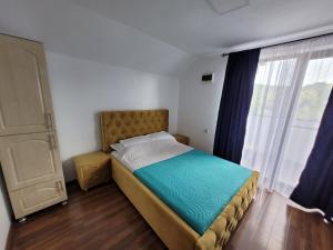 Un dormitorio pequeño con una cama y una ventana. en MaDaS, en Bărbăteşti