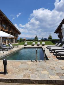 a swimming pool with lounge chairs and a resort at Rustic Spa at Pirin Golf in Razlog