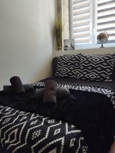 um quarto com 2 camas e um cobertor preto e branco em Les 4 chênes - T2 refait à neuf em Le Pont-de-Beauvoisin