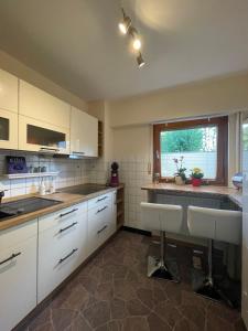 a kitchen with white cabinets and a large window at Ferienwohnung CONNI in Hellenthal